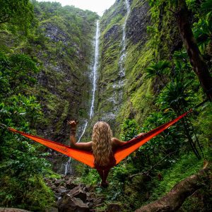 blonde girl in hammock in lush woods